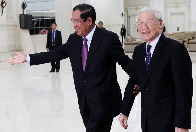 Former Cambodian Prime Minister Hun Sen, left, guides former Vietnamese President Nguyen Phu Trong during a visit to the Peace Palace in Phnom Penh, Feb. 26, 2019. (Heng Sinith/AP)