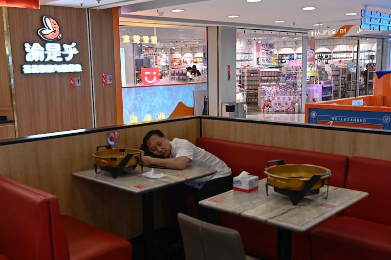 2024年8月14日,一名男子在北京一家购物中心的餐厅内休息。