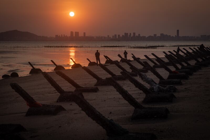 The sun sets over the Chinese city Xiamen as seen from anti-tank fortifications on April 9, 2023 on Kinmen, Taiwan.