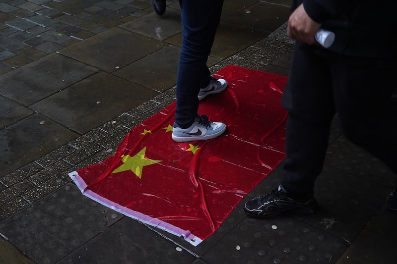 示威者把一面香港区旗和一面五星红旗,分别放在酒店入口处两侧地上,邀请途人践踏。 (RFA图片)